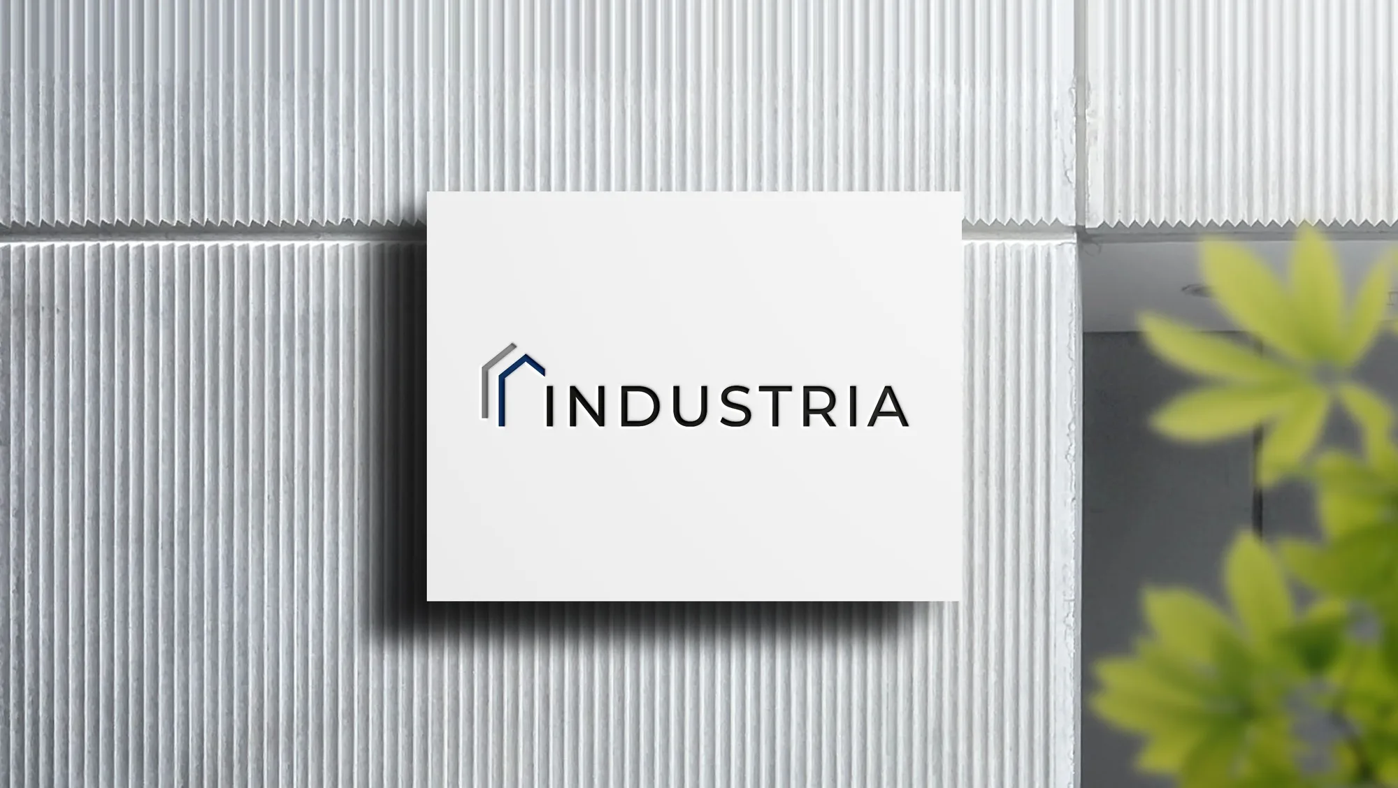 Wortmarke Industria auf weißer Tafel vor strukturierter Wand