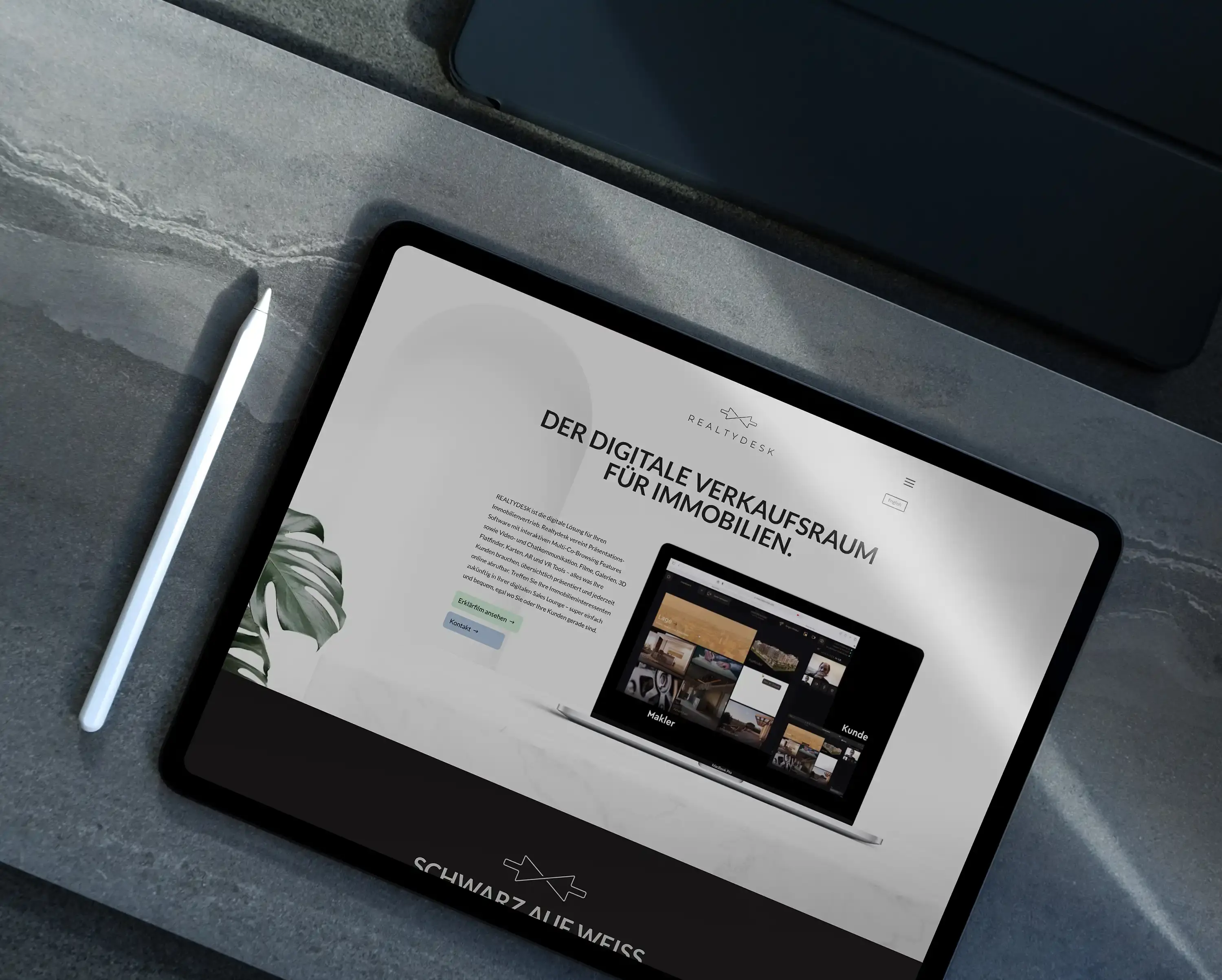Tablet auf einer Steinplatte mit der Realty-Desk-Website, daneben Stift und Pflanze