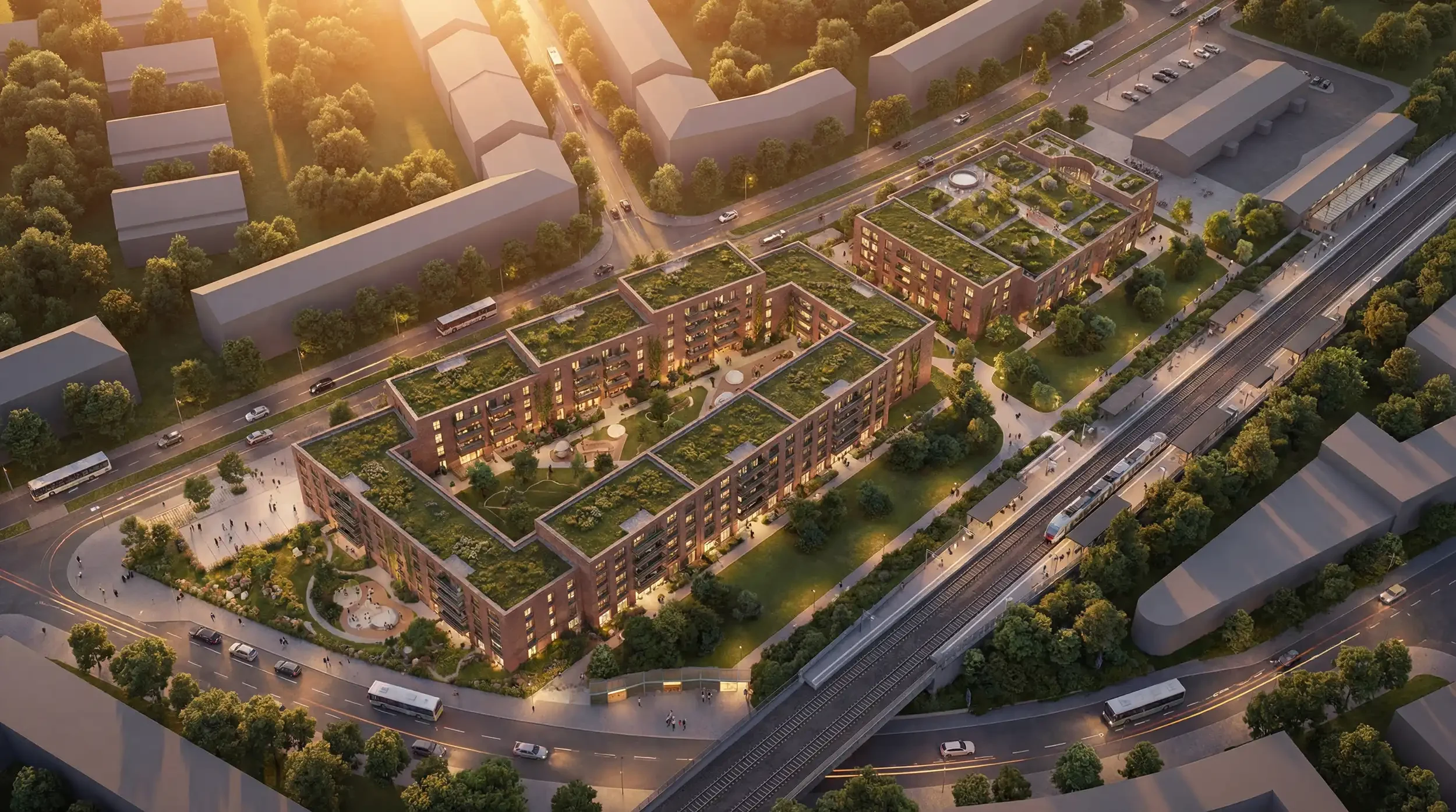 Luftbild des Quartiers mit begrünten Dächern und Innenhöfen am Bahnhof im Abendlicht