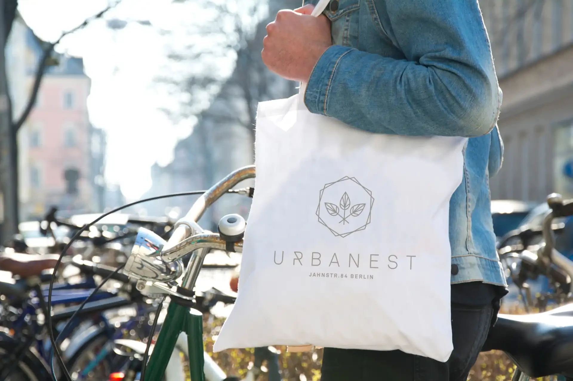 Stofftasche mit Urbanest-Logo vor Fahrrädern in der Stadt